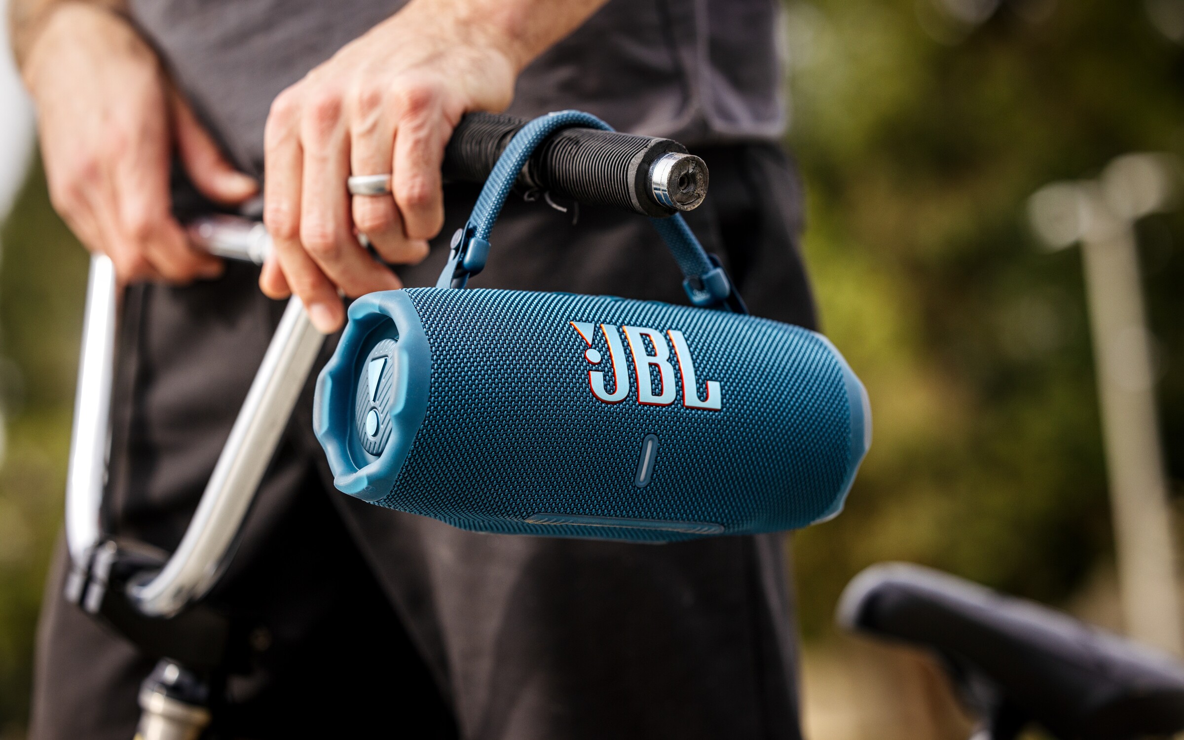 Blue JBL Charge 6 portable speaker carried beside a BMX bike